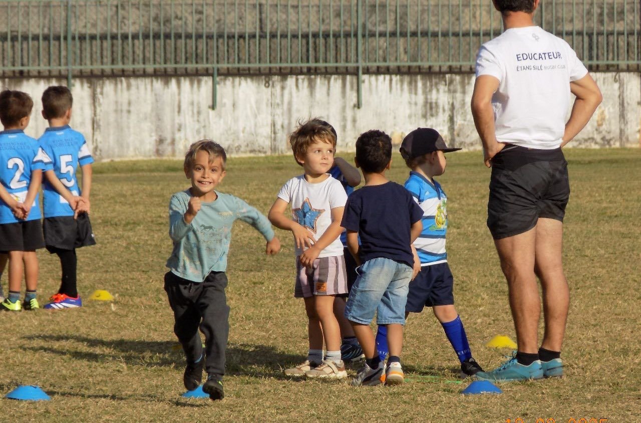 Un enfant de l'école de rugby court vers ses camarades pendant un atelier